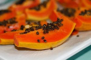 frisch geschnittene Papaya mit Samen auf Tablett. foto