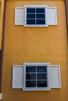 zwei Weiß Fenster und Gelb Farbe Mauer foto