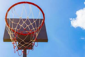 Outdoor-Basketballkorb mit blauem Himmel und Wolken foto