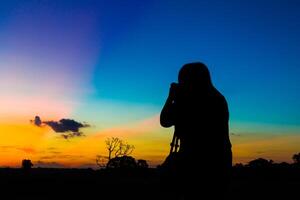 Silhouette Fotograf mit Sonnenuntergang foto