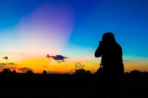 Silhouette Fotograf mit Sonnenuntergang foto