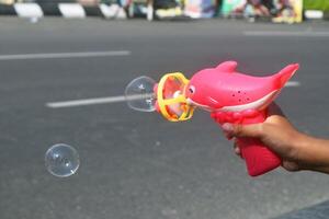 Spielzeuge im das bilden von Rosa Delfine knallen Seife Luftblasen foto