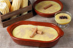 Curau, Sahne von Mais Süss und Dessert typisch von das Brasilianer Küche, platziert im Keramik Schüssel auf hölzern Tisch. foto