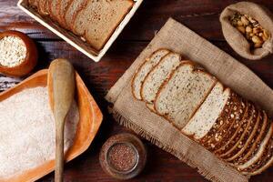 ganze Weizen Brot mit Körner und Saat geschnitten auf hölzern Tabelle foto