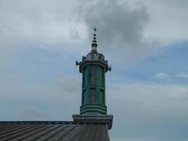 Foto von das Moschee Turm genommen von das oben Fußboden von ein mehrstöckig Gebäude. das Moschee Turm ist benutzt wie ein Marker und ebenfalls wie ein Lautsprecher