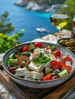 griechisch Salat mit Tomaten, Gurken, Weiß Feta Käse, Oliven und das Meer im das Hintergrund foto