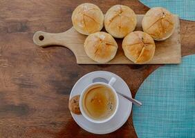 oben Aussicht von Knoblauch Brot und Tasse von Milch Kaffee auf hölzern Tablett. foto