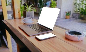 Laptop und Smartphone auf hölzern Schreibtisch beim das Cafe Bar. foto