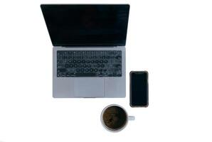 oben Aussicht von leer Bildschirm Laptop, Clever Telefon, Tasse von Kaffee, isoliert auf Weiß Hintergrund. foto