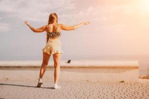 Frau Sommer- tanzen. Silhouette von ein glücklich Frau Wer Tänze, dreht sich und erhöht ihr Hände zu das Himmel. ein spielerisch jung Frau genießt ihr glücklich Moment Tanzen im das Strahlen von das golden Sonne. foto