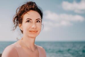 Frau Reise Meer. sportlich glücklich Mitte alt posieren auf ein Strand in der Nähe von das Meer auf Hintergrund von vulkanisch Felsen, mögen im Island, Teilen Reise Abenteuer Reise foto