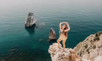 Frau Reise Meer. glücklich Tourist genießen nehmen Bild draußen zum Erinnerungen. Frau Reisender sieht aus beim das Kante von das Cliff auf das Meer Bucht von Berge, Teilen Reise Abenteuer Reise foto