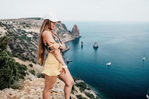 Frau Reise Meer. glücklich Tourist nehmen Bild draußen zum Erinnerungen. Frau Reisender sieht aus beim das Kante von das Cliff auf das Meer Bucht von Berge, Teilen Reise Abenteuer Reise foto