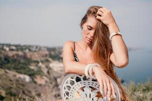 glücklich Boho Frau Porträt. Boho schick Mode Stil. draussen Foto von kostenlos glücklich Frau mit lange Haar, sonnig Wetter draußen mit Meer Berge Natur schön Hintergrund.