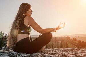 Fitness Frau. glücklich mittleren Alters Fitness Frau tun Dehnen und Pilates auf ein Felsen in der Nähe von Wald beim Sonnenuntergang. weiblich Fitness Yoga Routine. gesund Lebensstil mit Fokus auf Wohlbefinden und Entspannung. foto