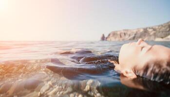 Frau Schwimmen im Meer beim Sonnenuntergang, schweben auf Ruhe Wasser zurück Sicht. Konzept von Körper Bild und Fitness, genießen ein heiter Strand. glücklich Frau mit perfekt passen Körper genießt Meer Strand foto