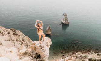 Frau Reise Meer. glücklich Tourist genießen nehmen Bild draußen zum Erinnerungen. Frau Reisender sieht aus beim das Kante von das Cliff auf das Meer Bucht von Berge, Teilen Reise Abenteuer Reise foto