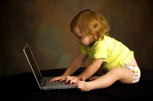 klein Mädchen funktioniert mit das Computer foto