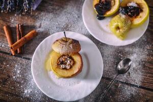 ausgestopft gebacken Apfel mit Nüsse, Honig und Schokolade auf Weiß Dessert Platten, dunkel hölzern Hintergrund. Weihnachten süss. gesund Essen Konzept. foto