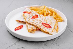 käsig Hähnchen Quesadilla mit Französisch Fritten foto