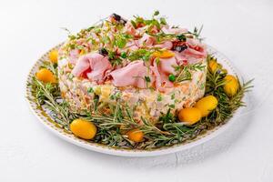 festlich Schinken und Kraut geschichtet Olivier Salat auf Teller foto