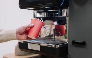 Hand Füllung rot Tasse beim Kaffee Maschine foto