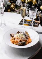 elegant Meeresfrüchte Pasta Gericht mit Champagner auf festlich Tabelle foto