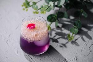 elegant lila Cocktail mit Blumen- Garnierung foto