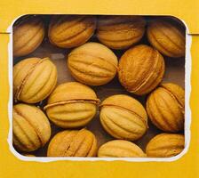 hausgemacht Nüsse Kekse im Gelb Box auf Weiß Hintergrund foto