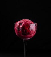 elegant Glas von Erdbeere Sorbet auf schwarz Hintergrund foto