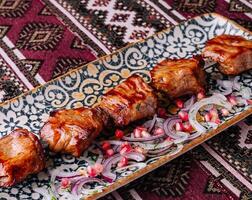traditionell gegrillt Kebab auf aufwendig Teller foto