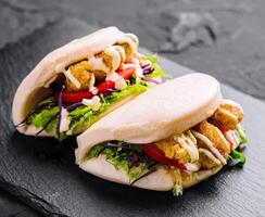 köstlich Gourmet Hähnchen bao Sandwiches auf Schiefer foto