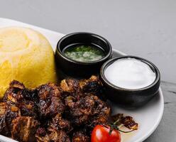 traditionell Polenta Gericht mit Fleisch und Saucen foto