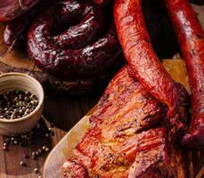 Sortiment von geräuchert Fleisch auf hölzern Tafel foto