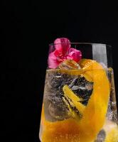 exotisch Cocktail mit Orange Twist und Blumen foto