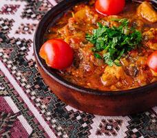 traditionell Lehm Topf Eintopf mit frisch Kräuter foto