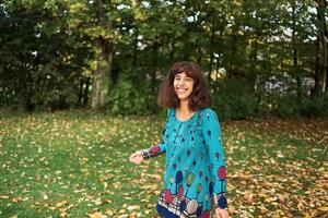 ein Mädchen im ein Kleid mit Luftballons ist spielen im das Herbst Garten foto