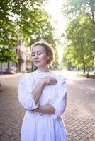 schick Mitte Alter Frau im ein Weiß Jahrgang Kleid im ein sonnendurchflutet Gasse foto