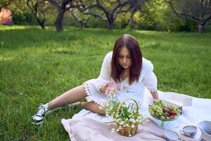 ein Porträt von ein Teenager Mädchen im ein Pastell- Kleid auf ein Picknick foto