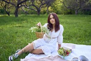 ein Porträt von ein Teenager Mädchen im ein Pastell- Kleid auf ein Picknick foto