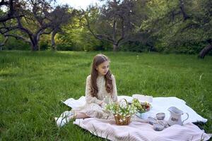 ein Porträt von ein Teenager Mädchen im ein Pastell- Kleid auf ein Picknick foto