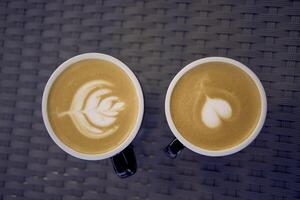 zwei Tassen von Kaffee, Latté und Cappuccino auf ein Tabelle im ein Cafe foto