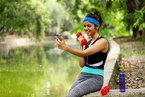 schlank Frau im Fitnessstudio passen und Stirnband halten Hantel im Hand foto