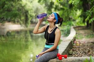 Frau Trinken Wasser nach Übung foto