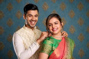 ein indisch Paar im traditionell Outfit präsentieren Halskette zu seine Ehefrau foto