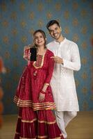 ein Bilderbuch Mode Paar posiert zum das Kamera während anziehen traditionell Kleidung zum das Diwali Feier foto