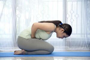 schön indisch Frau tun mandukasana Yoga Pose foto