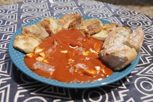 Spanisch Essen, gebacken Aubergine mit kalt Tomate Suppe namens salmorejo mit gekocht Ei und roh Schinken foto