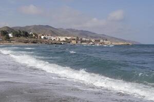 Bucht von Villaricos, Rau Meer, Strand, Dorf und Berge beim das Hintergrund foto