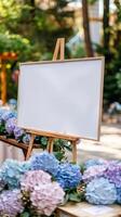 ein Weiß leer horizontal Poster auf Staffelei im Vorderseite von Hochzeit Rezeption Tabellen mit Pastell- Blau und lila Farben Hortensie Blumen foto
